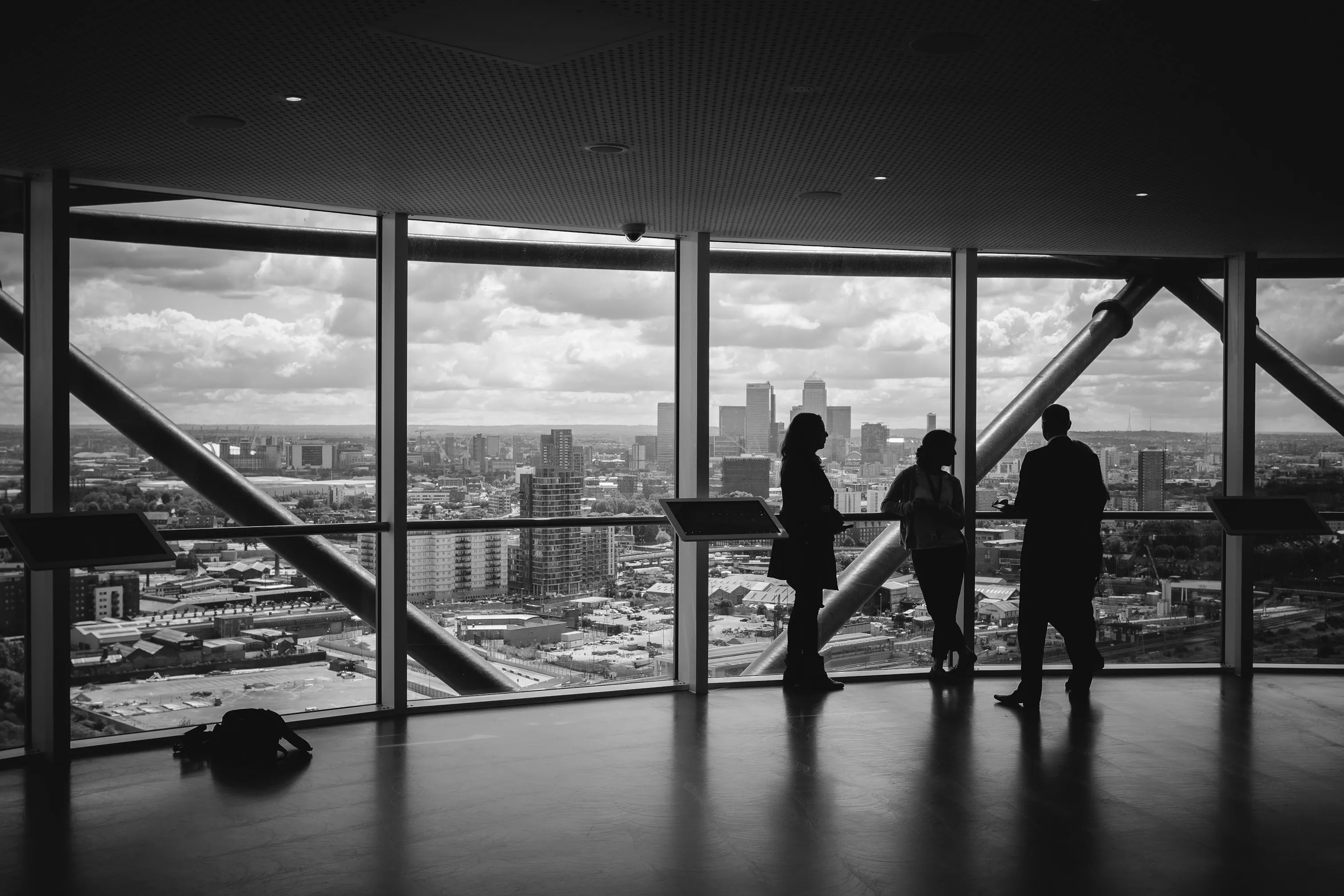 Silhouettes looking out over a city skyline through floor-to-ceiling windows