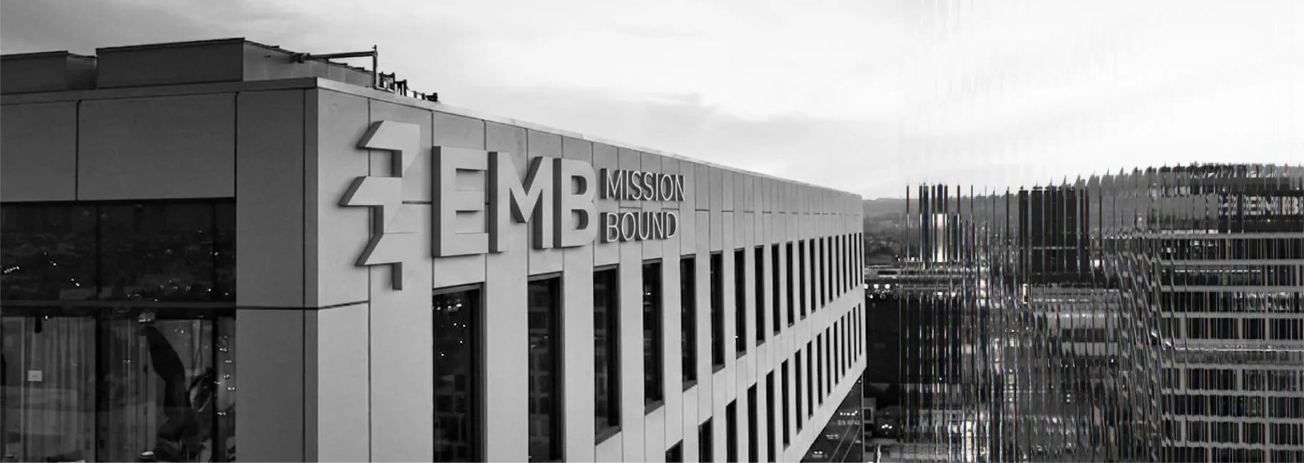 EMB Mission Bound office building with the company name on the facade, overlooking a city street