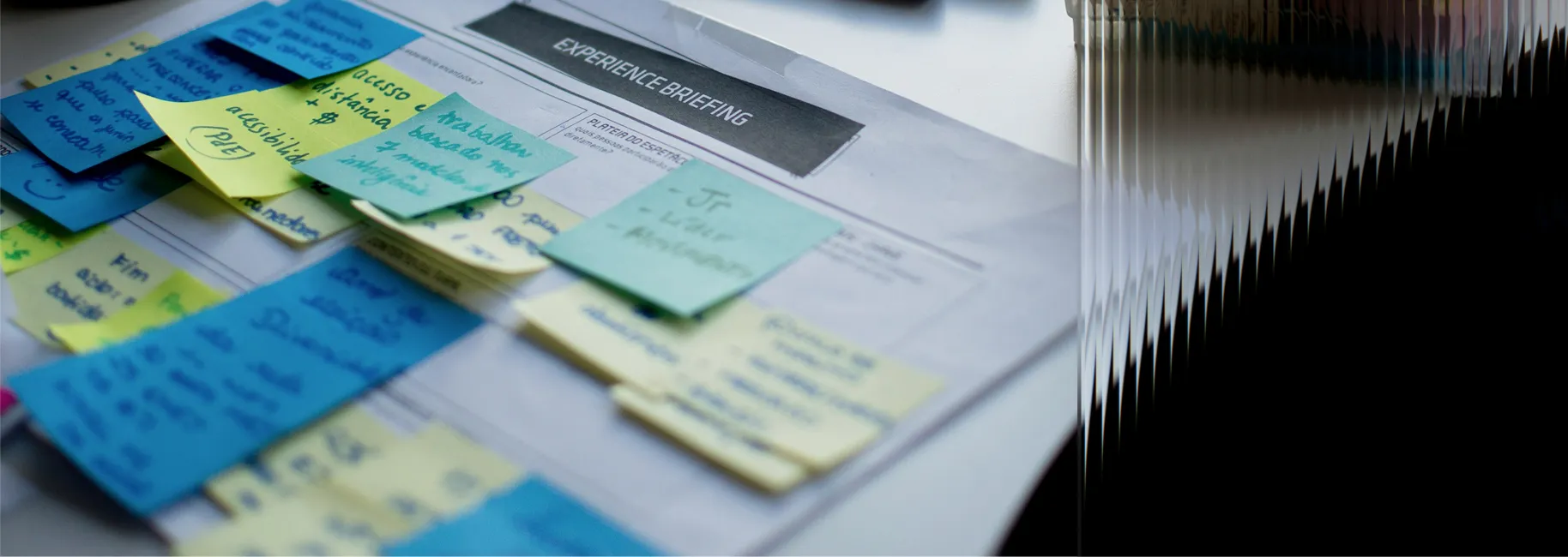 Workspace document covered with colourful sticky notes during an experience briefing