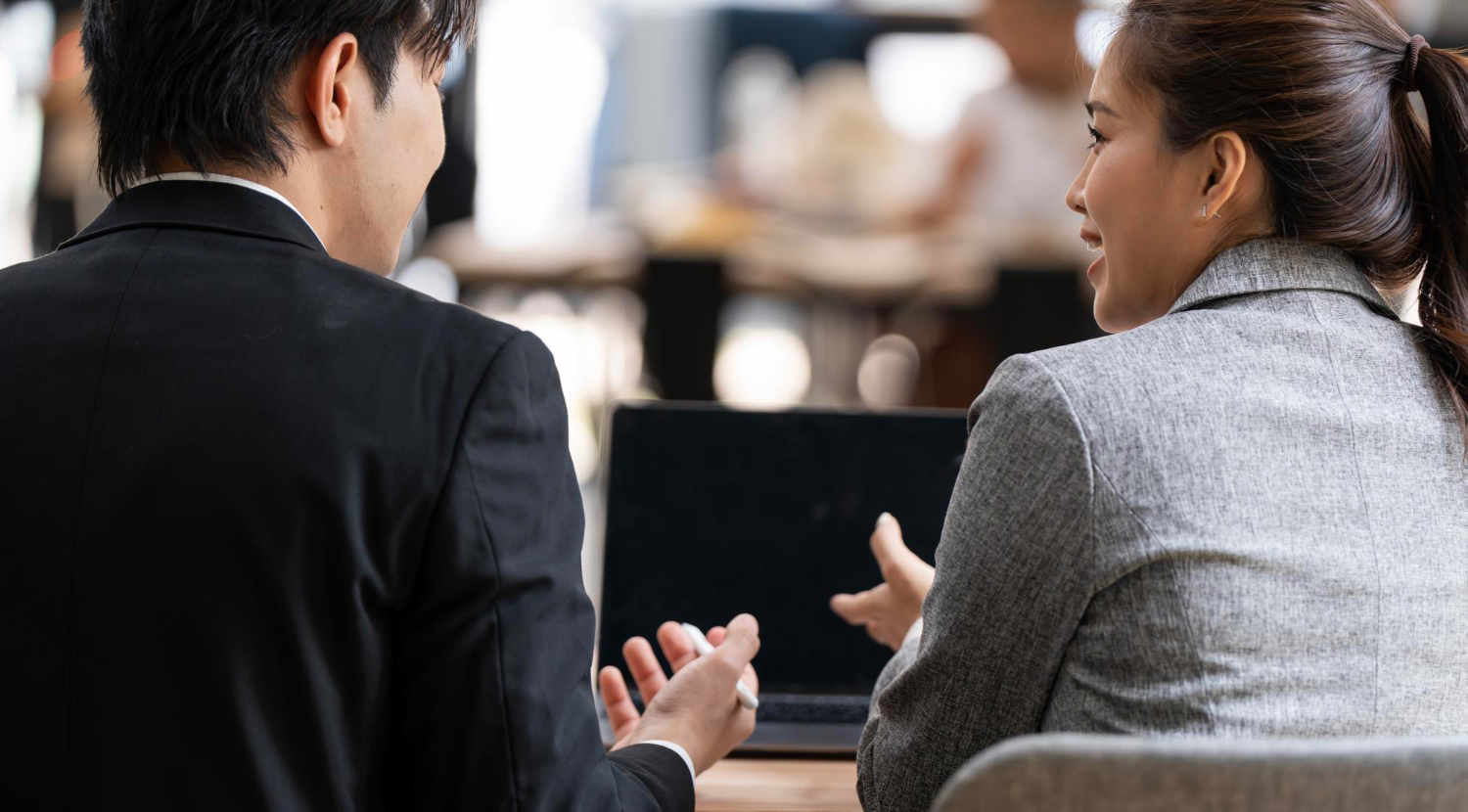 Two colleagues talking at a laptop